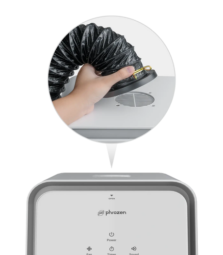 Close up of a hand attaching a black flexible exhaust hose to the top port of the Phrozen Air Purifier Max, with the full unit shown below.