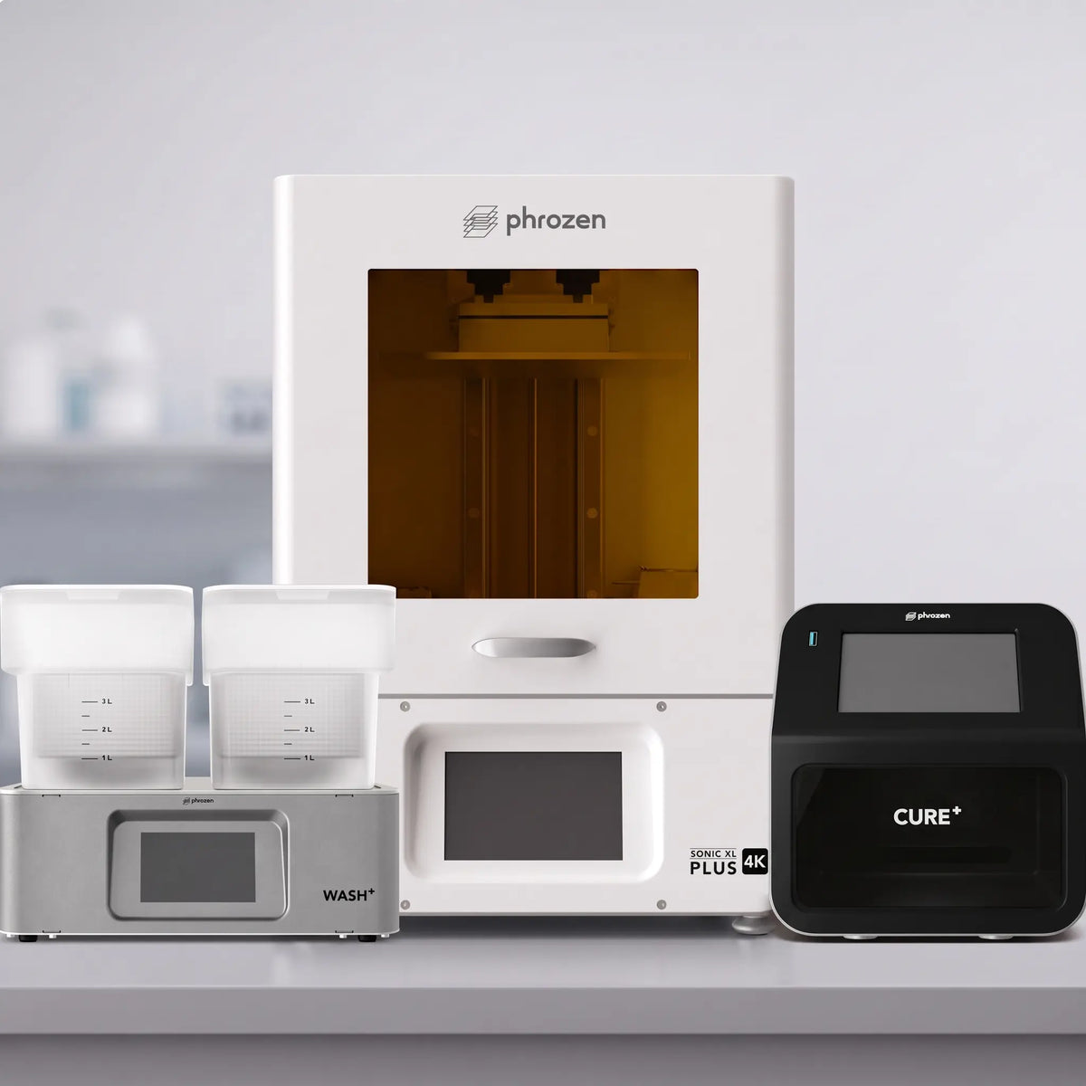 Phrozen Sonic XL Plus 4K resin 3D printer with an amber lit build chamber, positioned between the Wash+ washing unit and Cure+ curing unit.