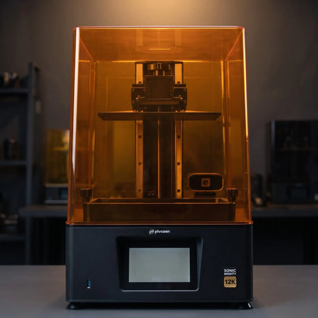 Phrozen Sonic Mighty 12K resin 3D printer front view on dark studio desk with warm pendant lighting